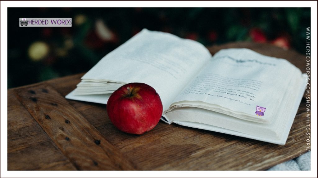an open book and a red apple