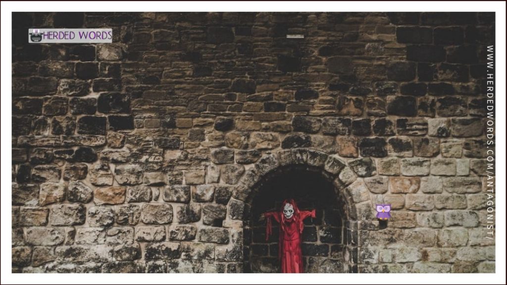 A person in a red robe and mask standing in an old wall